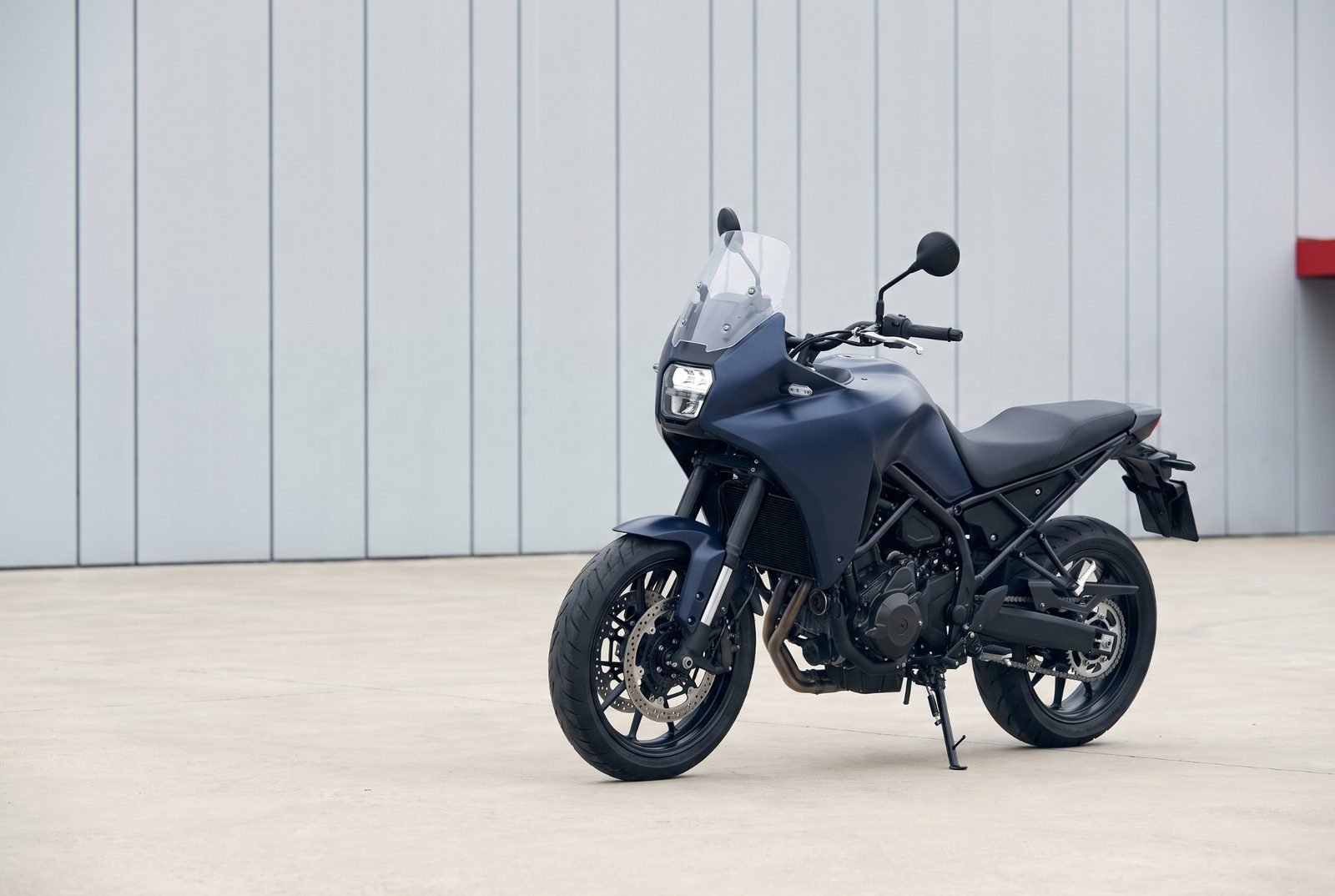 Granatowy motocykl turystyczny na betonowym placu